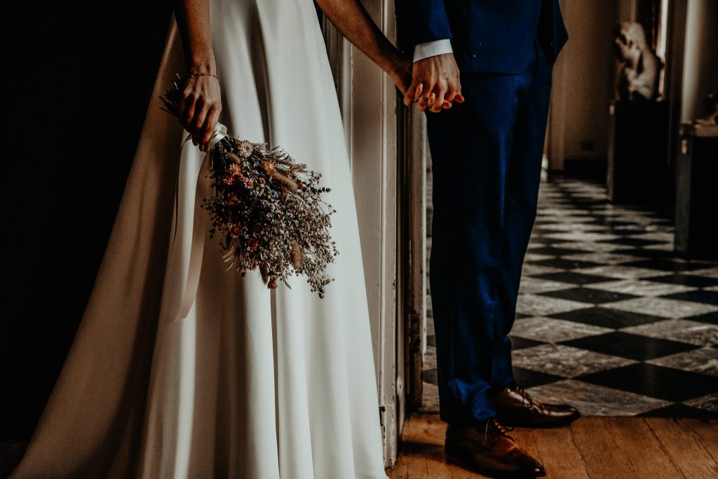 Brautpaar hält sich an den Händen während der Hochzeit