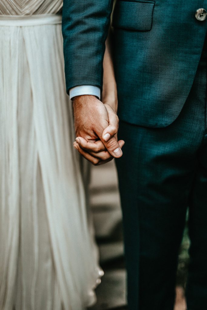 Brautpaar hält sich während der Hochzeit an den Händen