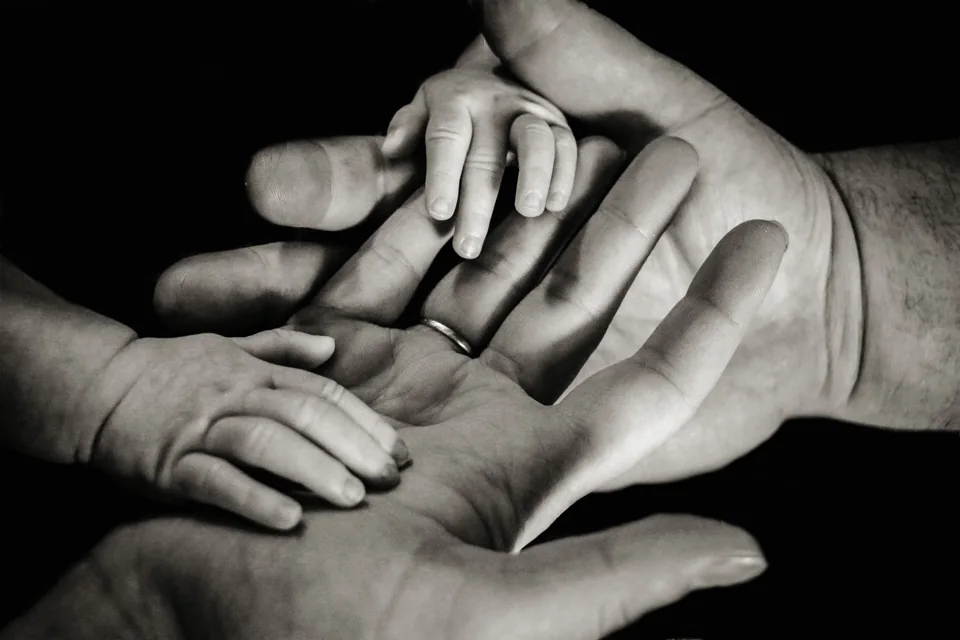 Kleine Kinderhand in den Händen der Eltern