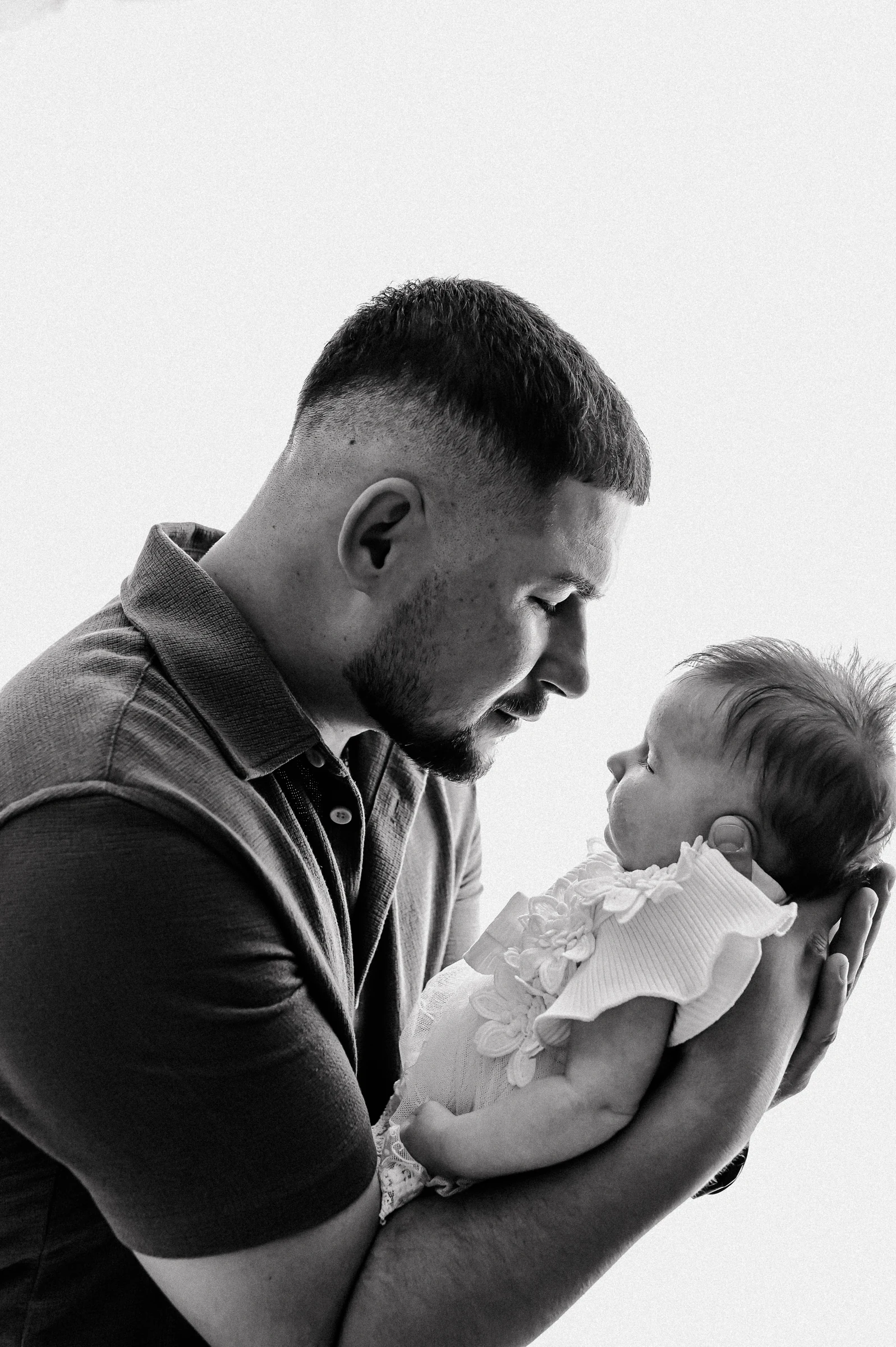Ein Mann blickt auf das Baby in seinen Armen