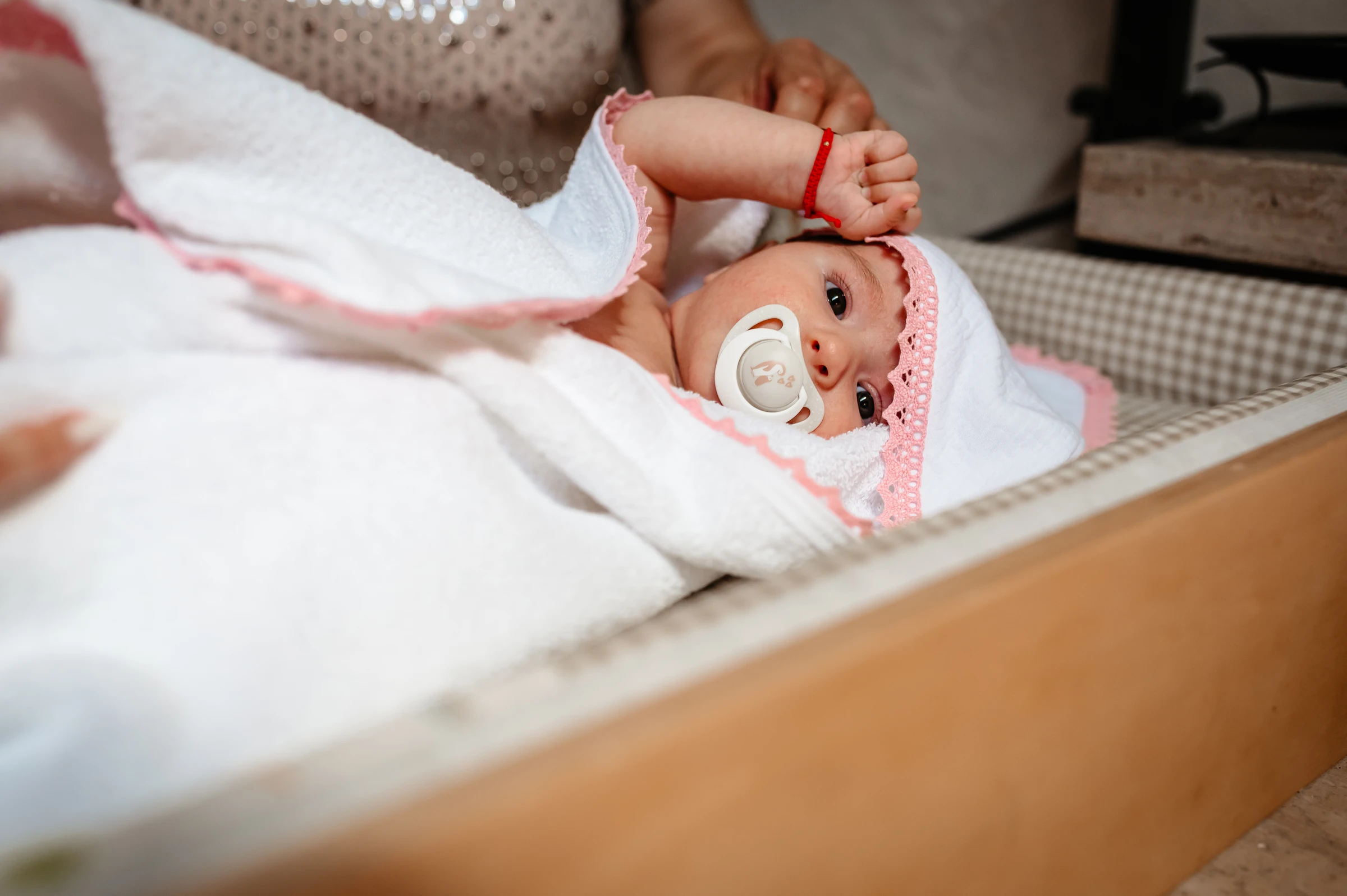 In ein weißes Tuch gewickeltes Baby während der Taufe