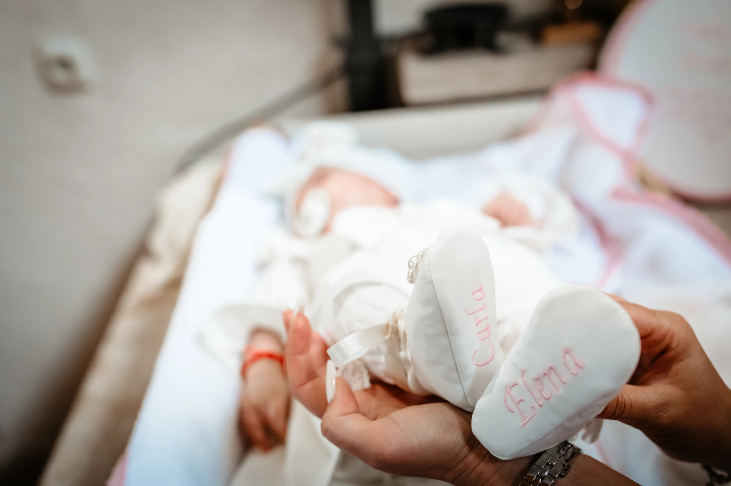 Kleine weiße Babyschuhe und behutsam haltende Hände