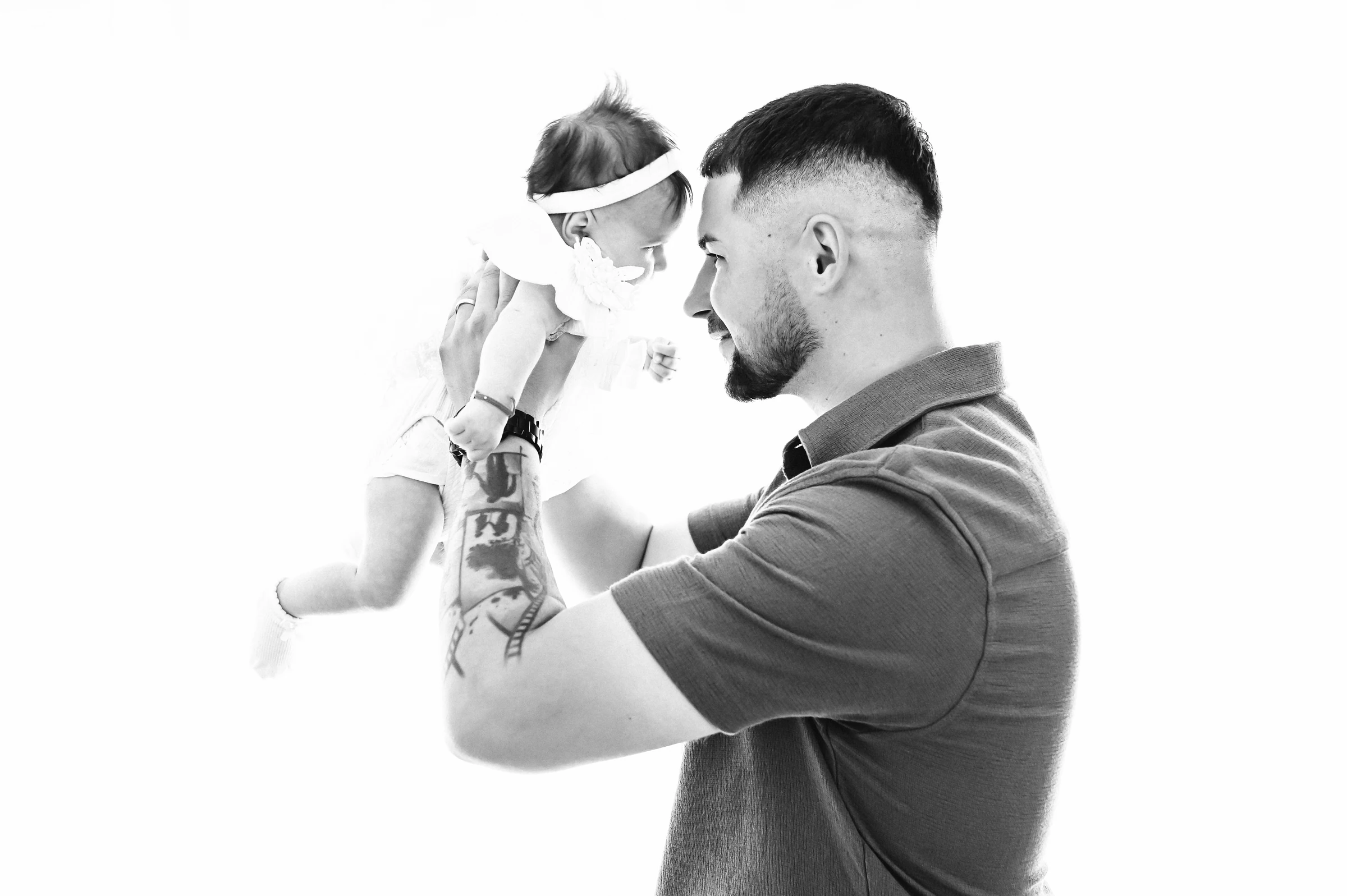 Ein Mann hält das Baby auf Augenhöhe – Schwarzweißaufnahme